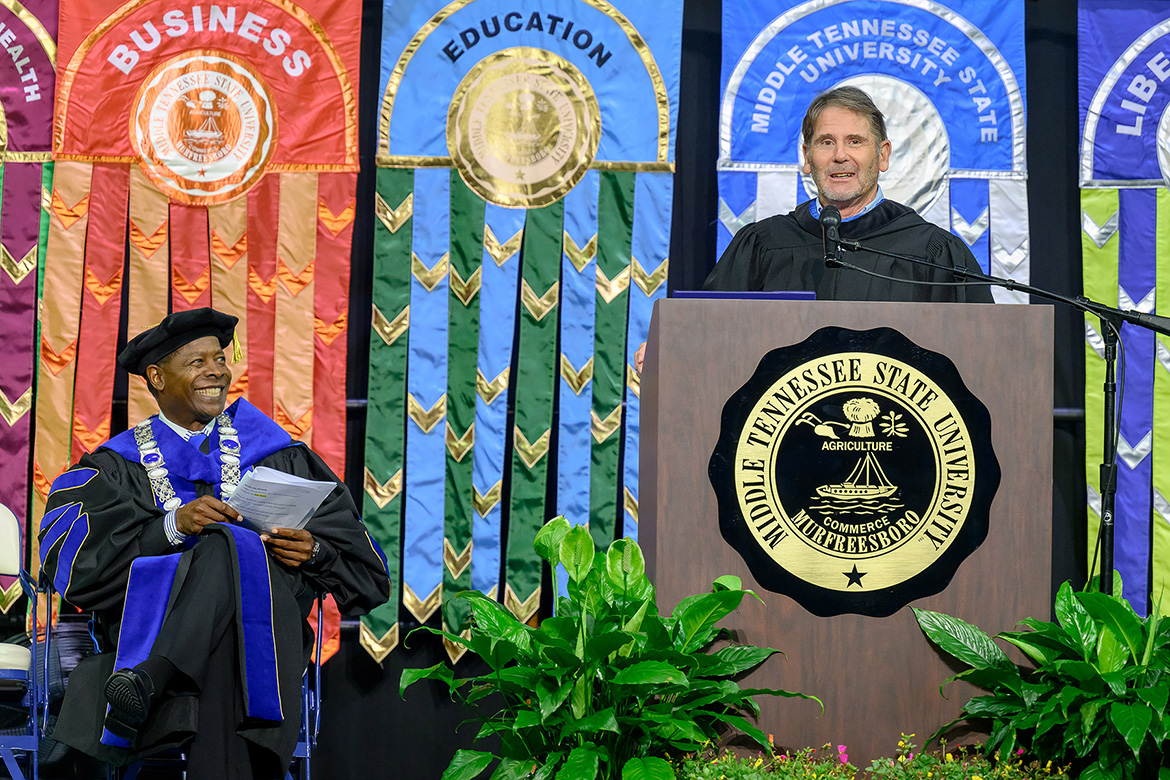 Author and journalist Bob Welch elicits a laugh from Middle Tennessee State University President Sidney A. McPhee, seated right, during Welch’s keynote remarks at the 2025 Convocation ceremony held Saturday, Aug. 23, in Murphy Center on campus in Murfreesboro, Tenn. (MTSU photo by J. Intintoli)