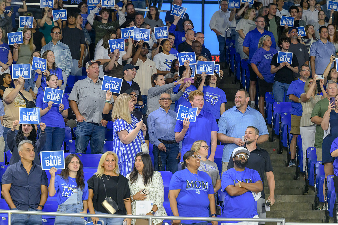 Surrounded by friends and family, new Middle Tennessee State University students hold up “I Am True Blue” signs toward the end of the 2025 Convocation ceremony held Saturday, Aug. 23, in Murphy Center on campus in Murfreesboro, Tenn. (MTSU photo by J. Intintoli)