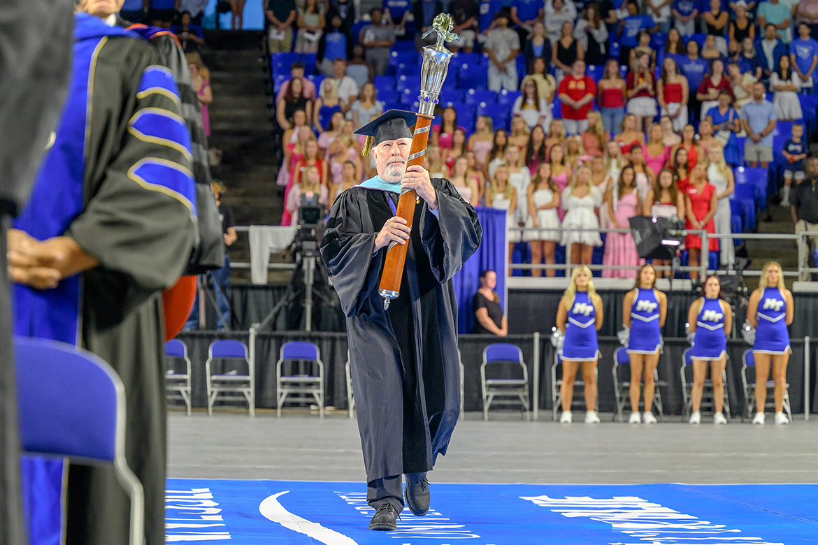 Paul Craig, aerospace professor at Middle Tennessee State University in Murfreesboro, Tenn., carries the mace into Hale Arena inside Murphy Center as part of the processional for the 2025 Convocation ceremony held Saturday, Aug. 23. (MTSU photo by J. Intintoli)