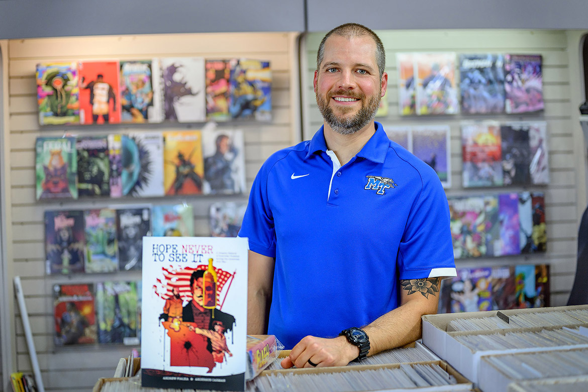 Middle Tennessee State University associate professor of history Andrew Fialka stands with his newly released book, “Hope Never to See It: A Graphic History of Guerrilla Violence during the American Civil War,” inside The Great Escape in Murfreesboro, Tenn. Written by Fialka and illustrated by award-winning artist Anderson Carman, the book is a graphic history that illustrates two incidents of occupational and guerrilla violence in Missouri during the Civil War. (MTSU photo by J. Intintoli)