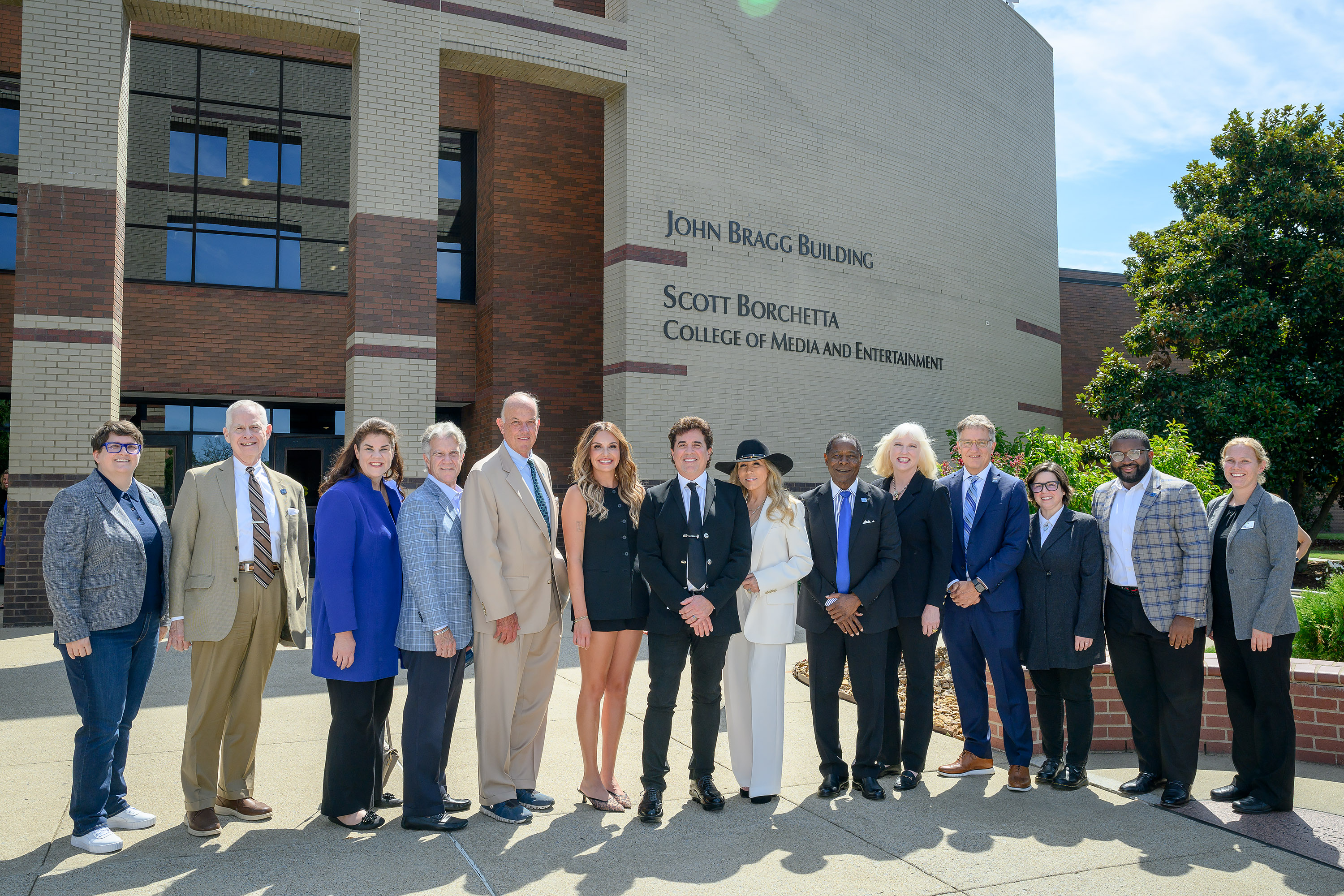 Scott Borchetta, center in black suit, Big Machine Label Group founder, chairman and CEO, is all smiles Tuesday, Aug. 26, following the unveiling ceremony officially renaming Middle Tennessee State University’s media college to the Scott Borchetta College of Media and Entertainment. Pictured, from left, outside John Bragg Building on campus in Murfreesboro, Tenn., Michelle Conceison, Recording Industry chair; MTSU Trustee Tom Boyd; state Sen. Dawn White; Trustee Bill Jones; Trustee Chairman Stephen Smith; Big Machine artist Carly Pearce; Borchetta; his wife, Sandi; MTSU President Sidney A. McPhee; Dean Beverly Keel; Provost Mark Byrnes; Faculty Trustee Kari Neely; Student Trustee Michai Mosby; and MTSU Journalism School Director Katie Foss. (MTSU photo by J. Intintoli)