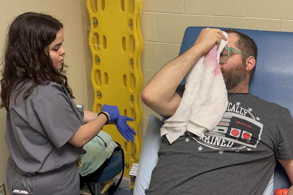 Samantha Freda, a first-year Physician Assistant Studies student at Middle Tennessee State University in Murfreesboro, Tenn., examines E. Roy Lee, an actor portraying an injured patient, during a mock mass casualty simulation held in July inside Cason-Kennedy Nursing Building on campus. The test training mimics a real-world situation, using actors and high-fidelity patient mannequins to give students hands-on training before starting a year of clinical rotations in the second year of the 27-month program. (MTSU photo by Nancy DeGennaro)