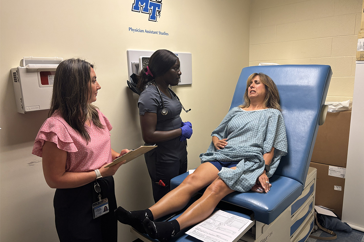 Ashley Bjork, left, a clinical associate professor in the Physician Assistant Studies program at Middle Tennessee State University in Murfreesboro, Tenn., accompanies first-year student Nayatuil “Twilly” Tongyik, of Gallatin, Tenn., to examine a patient-actor during a mock mass casualty simulation held in July inside the Cason-Kennedy Nursing Building. Tongyik diagnosed the patient-actor with bleeding in the abdomen — the correct assessment. (MTSU photo by Nancy DeGennaro)
