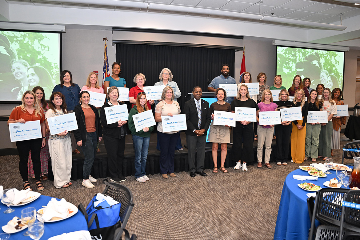 Middle Tennessee State University President Sidney A. McPhee, center, takes a group photo with a group of about 20 high school and college counselors who attended a luncheon as part of MTSU’s True Blue Tour student recruitment stop on Thursday, Sept. 18, at the Leslie Town Centre in Cookeville, Tenn. McPhee presented $50,000 in scholarships to representatives from the attending institutions. (MTSU photo by James Cessna)