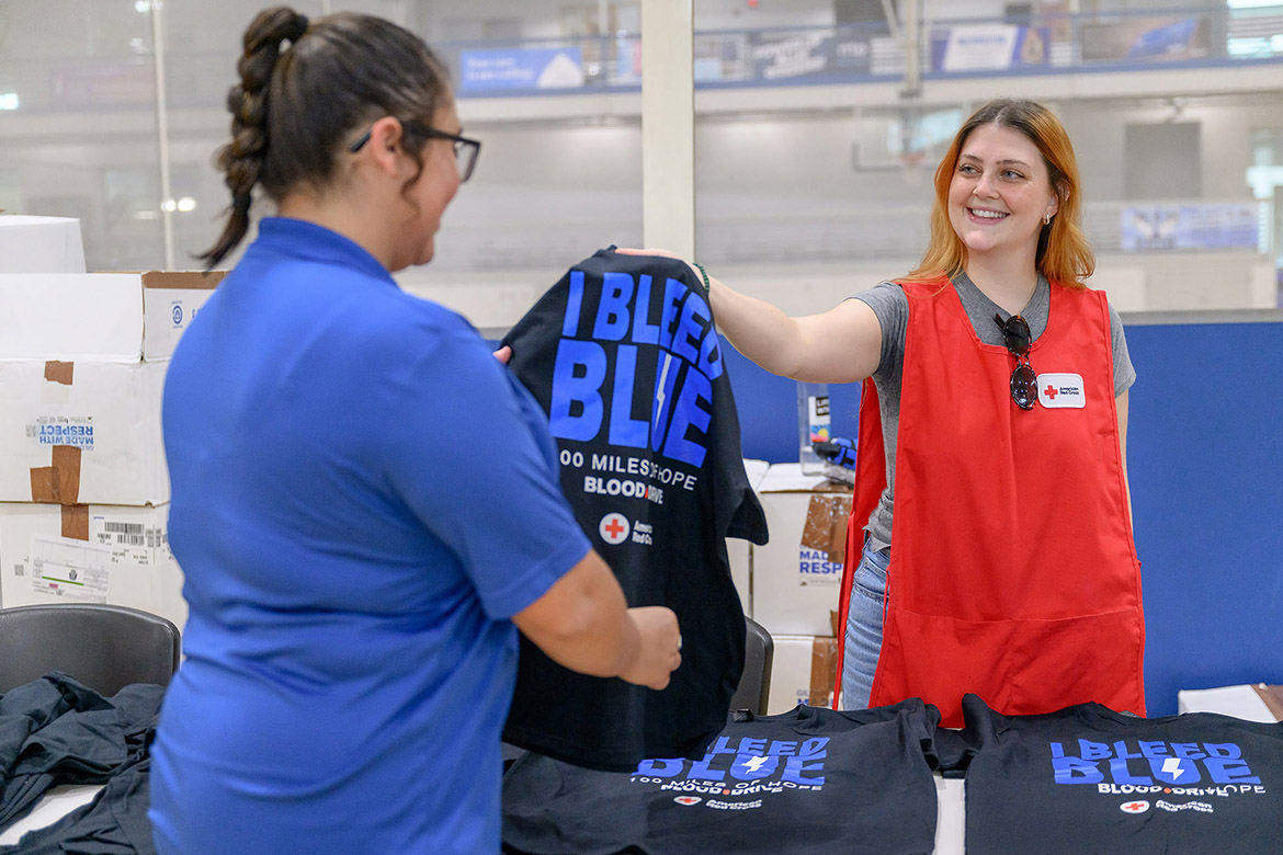 A volunteer at the 2024 “Bleed Blue to Beat WKU” blood drive hands out a free T-shirt to a donor at the event held in the fall. Donors and volunteers are also needed for this year’s event, which is set for noon to 6 p.m. Monday-Wednesday, Oct. 27-29, at Campus Recreation Center, 1848 Blue Raider Drive in Murfreesboro, Tenn. Donors will get free pizza, gift cards, T-shirts and football tickets this year. (MTSU file photo by J. Intintoli)