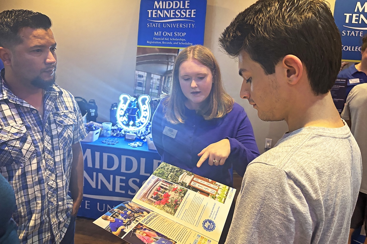 Rachel Morales, center, Middle Tennessee State University MT One Stop enrollment coordinator, discusses scholarship opportunities for incoming freshmen with a prospective student and his father at the True Blue Tour event to recruit prospective students on Thursday, Oct. 16, at Bridgewater Place in Knoxville, Tenn. (MTSU photo by Randy Weiler)