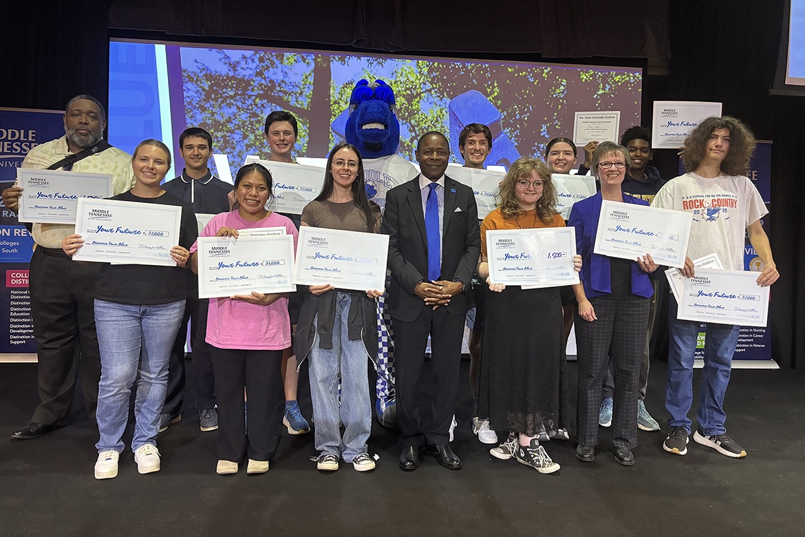 Shown with Middle Tennessee State University President Sidney A. McPhee, front row center, 12 scholarship recipients from the Knoxville, Tenn., True Blue Tour recruiting event at Bridgewater Place on Thursday, Oct. 16, hold their big checks. MTSU will hold the scholarships for those who were high school underclassmen. (MTSU photo by Randy Weiler)