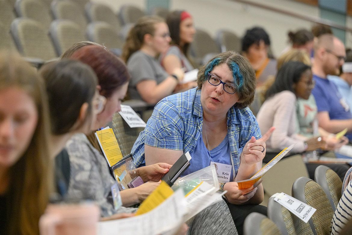 Bonny McCarty, an advisor in the College of Behavioral and Health Sciences at Middle Tennessee State University in Murfreesboro, Tenn., talks with her fellow participants in a poverty simulation held on campus recently. Participants were each assigned a character and family situation to navigate to mimic what it’s like to live below the poverty line. (MTSU photo by J. Intintoli)