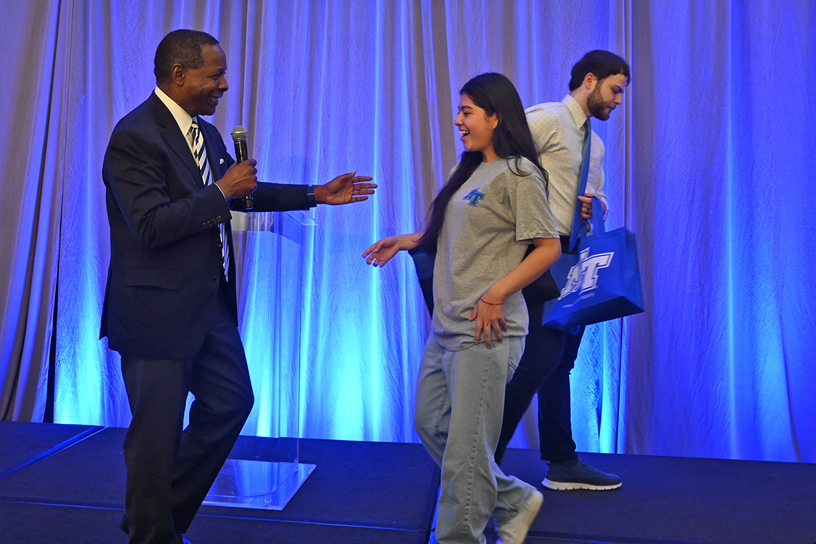 Middle Tennessee State University President Sidney A. McPhee, left, congratulates a surprised Danitza Gonzalez, a senior at East Ridge High School in Chattanooga, Tenn., after her name was drawn for a $1,000 scholarship during the university’s True Blue Tour student recruitment reception Sept. 25 at The Chattanoogan Hotel in Chattanooga, Tenn. (MTSU photo by Jimmy Hart)