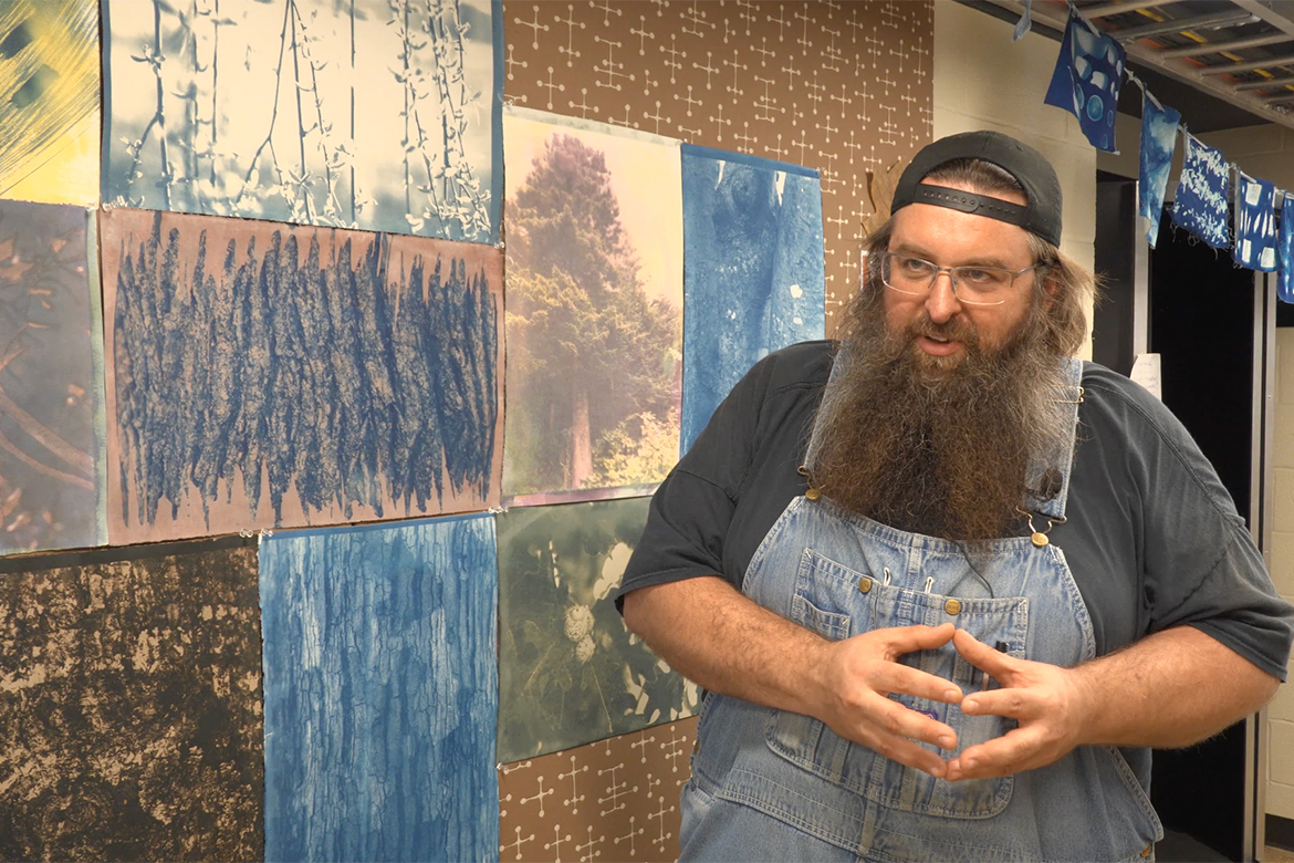 Middle Tennessee State University associate photography professor Jonathan Trundle stands in front of student Dawn Fós’ photos that hang in the hallway of the McFarland Building on campus in Murfreesboro, Tenn., documenting the more than 120 trees native to Tennessee. (MTSU photo)