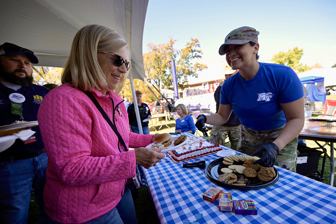 Middle Tennessee State University ROTC cadet Osiris Isidro, right, serves cookies to veterans and others attending the pregame Salute to Veterans and Armed Forces picnic in Walnut Grove on campus in Murfreesboro, Tenn., on Saturday, Nov. 8.  (MTSU photo by Cat Curtis Murphy)