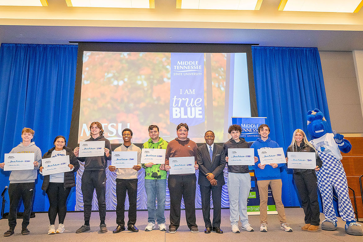 Middle Tennessee State University President Sidney A. McPhee, center, stands with students who were among the lucky winners in the scholarship drawings at MTSU’s True Blue Tour recruitment stop for prospective students held Tuesday, Nov. 11, in the Student Union Ballroom on campus in Murfreesboro, Tenn. Eleven students took home a total of $16,200 in scholarships at the evening event. (MTSU photo by Cat Curtis Murphy)