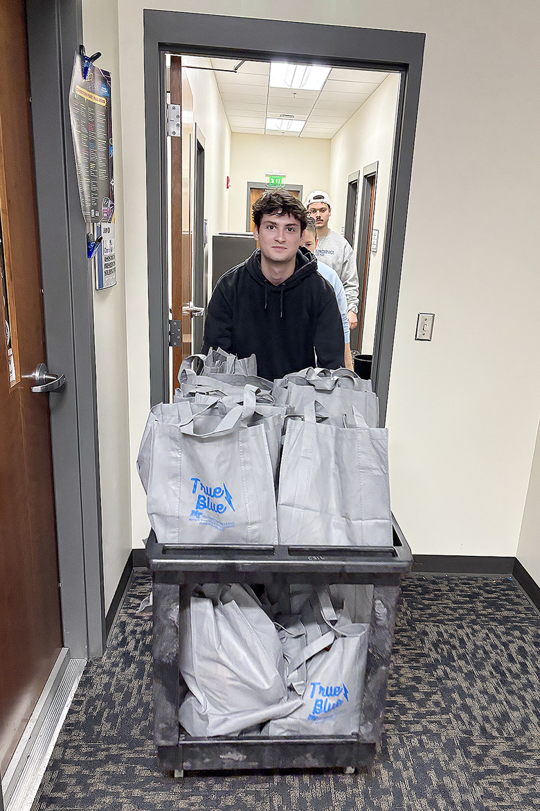A student in the Honors College at Middle Tennessee State University in Murfreesboro, Tenn., rolls a cart filled with Thanksgiving meal bags that will benefit students in need on campus this holiday season. Student volunteers collected and assembled a total of 109 Thanksgiving meal bags inside the Student Union that were distributed Thursday, Nov. 6, as part of the First-Year and Nontraditional Student Engagement’s annual Thankful Thursday initiative. (MTSU photo by Nancy DeGennaro)