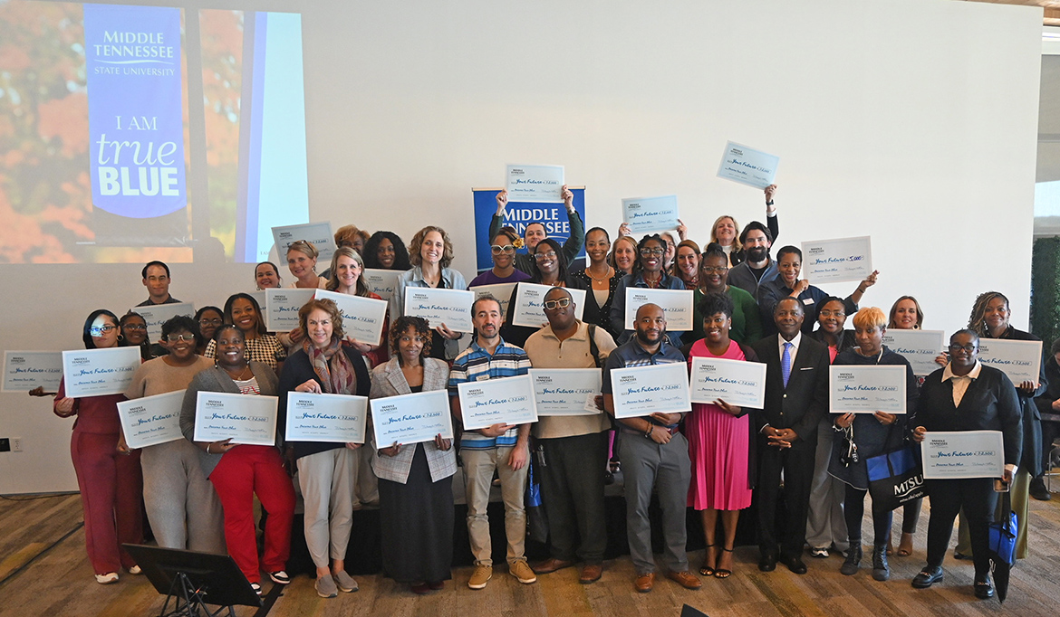 Middle Tennessee State University President Sidney A. McPhee, front row, third from right, is shown with West Tennessee high school guidance counselors and community college representatives holding their scholarship checks during the university’s True Blue Tour luncheon on Nov. 4 at the FedEx Event Center at Shelby Farms in Memphis, Tenn. McPhee awarded $145,000 to the institutions represented at the luncheon. (MTSU photo by Jimmy Hart)