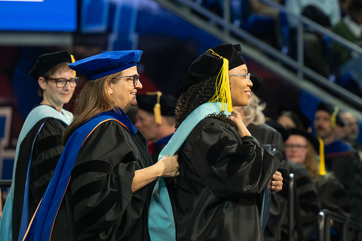 Middle Tennessee State University doctoral recipient Melnequa Holloway, right, is hooded by Angela Hooser, associate professor in the Department of Elementary and Special Education, during the fall 2025 commencement morning ceremony held Saturday, Dec. 13, in Murphy Center on the MTSU campus in Murfreesboro, Tenn. (MTSU photo by Cat Curtis Murphy)