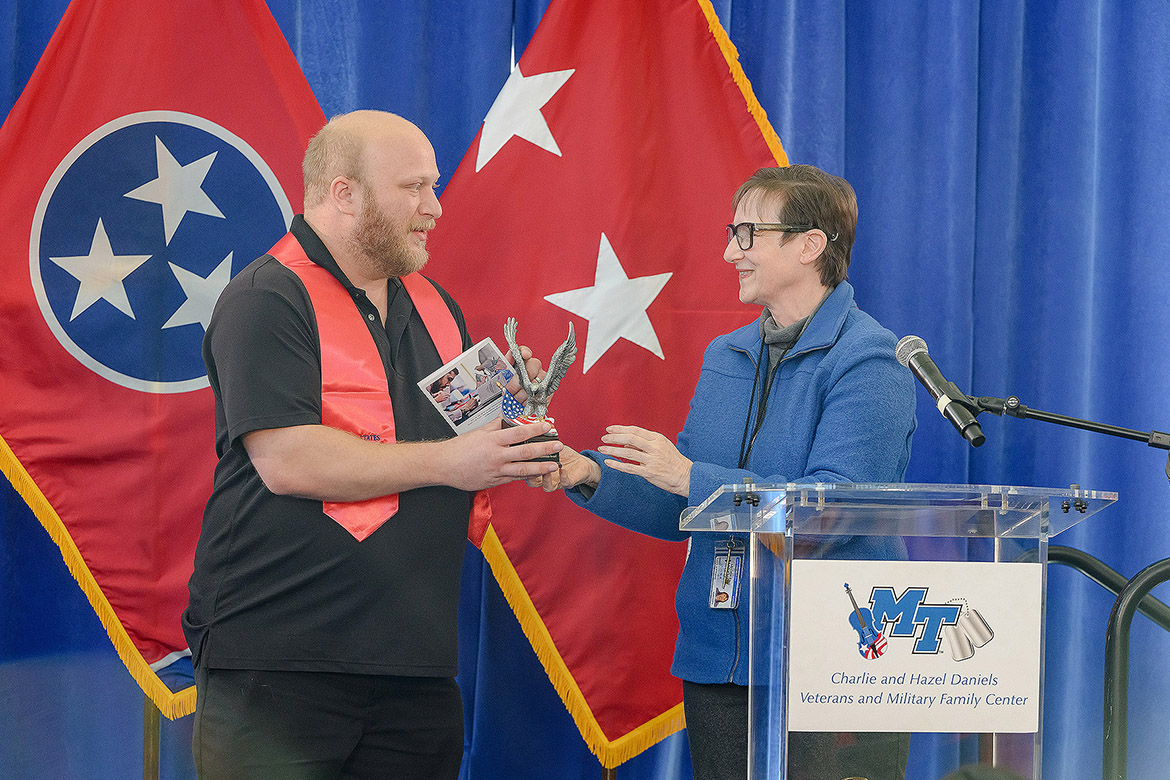 Laurie Witherow, vice provost for enrollment services at Middle Tennessee State University in Murfreesboro, Tenn., presents fermentation science major Hunter Lundgren with the Veterans Leadership Award at the 32nd Graduating Veterans Stole Ceremony held Thursday, Dec. 11, 2025, at Miller Education Center. (MTSU photo by Andy Heidt)