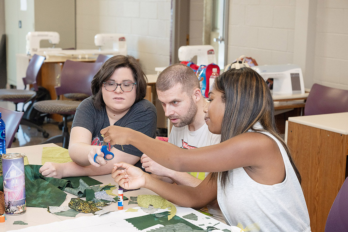 Borderless Arts Tennessee members Torie Summers, left, and Clinton Fyke, center, working with Middle Tennessee State University Noelle Jamison, a psychology major from Nashville, Tenn., in the Learning Resource Center sewing lab on campus in Murfreesboro, Tenn., before an art project that will be on display as part of the state’s celebration of the United States’ 250th anniversary. (MTSU photo by James Cessna)