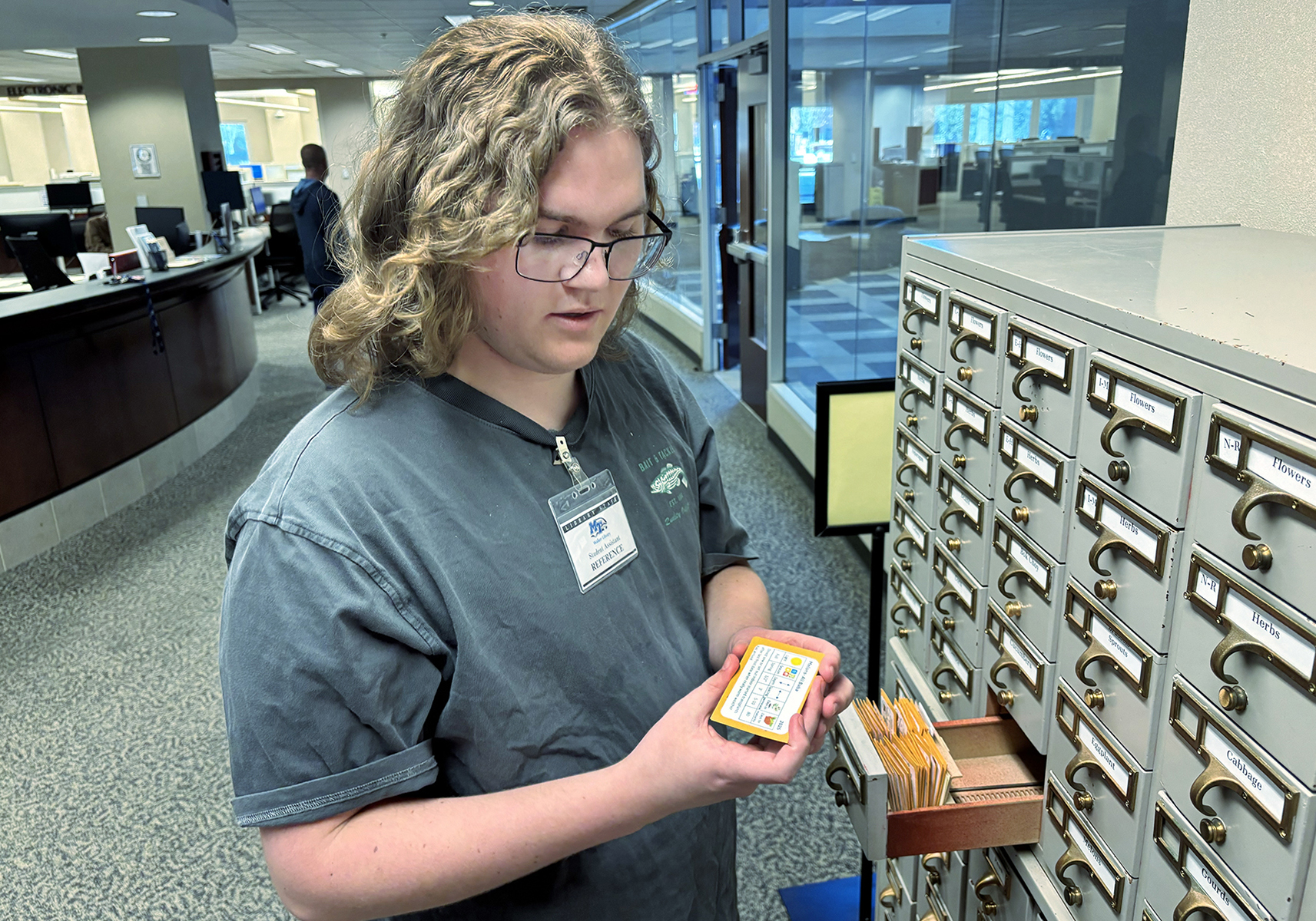 George Moistant, a junior accounting major at Middle Tennessee State University in Murfreesboro, Tenn., sorts through the Seed Library at James E. Walker Library on campus. The converted card catalog houses hundreds of seed packets that students can check out free of charge. The free service is one of hundreds of projects funded through the Sustainable Campus Fee over the past 20 years. (MTSU photo by Nancy DeGennaro)