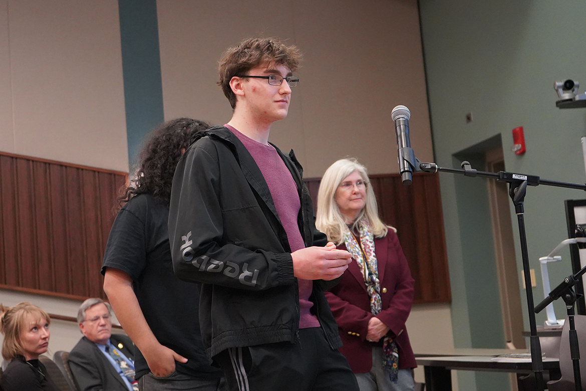 An attendee asks a question during the Q&A portion of a panel discussion about the current war in Iran on Thursday, March 19, at the College of Education Building on campus in Murfreesboro, Tenn. In the background at right is Middle Tennessee State University Honors College professor Joan McRae, who moderated the panel. (MTSU photos by Robin E. Lee)