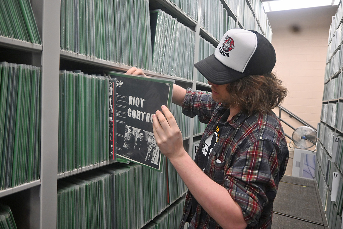 Harlow Crandall, archival assistant at the Center for Popular Music at Middle Tennessee State University in Murfreesboro, Tenn., is shown in the center’s storage area amid the Maximum Rocknroll punk music archive that arrived earlier this year. (MTSU photo by Jimmy Hart)