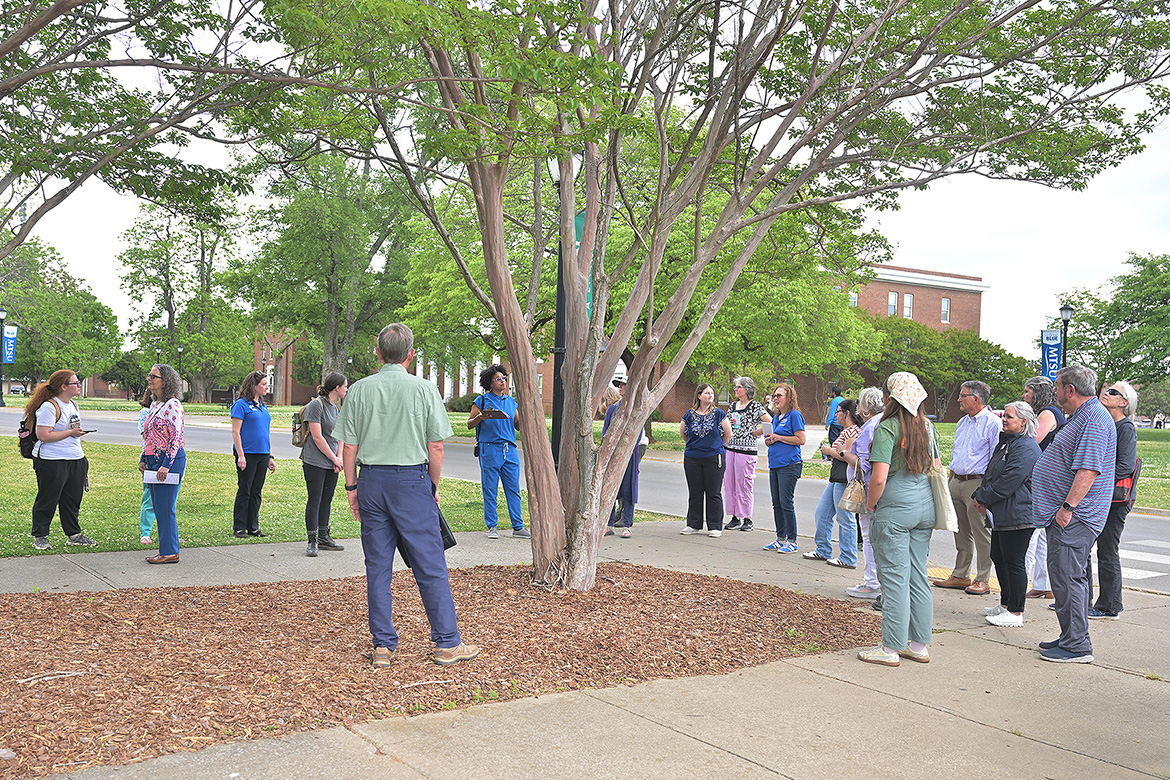 A crowd gathered Thursday, April 16, for the unveiling of the newly designated Level II Arboretum on the campus of Middle Tennessee State University in Murfreesboro, Tenn., stands underneath a crepe myrtle tree just outside Peck Hall as they listen to Department of Biology lecturer Danielle Brown talk. Certified by the Tennessee Urban Forestry Council, 73 trees have been tagged and mapped across the 500-acre campus. (MTSU photo by James Cessna)