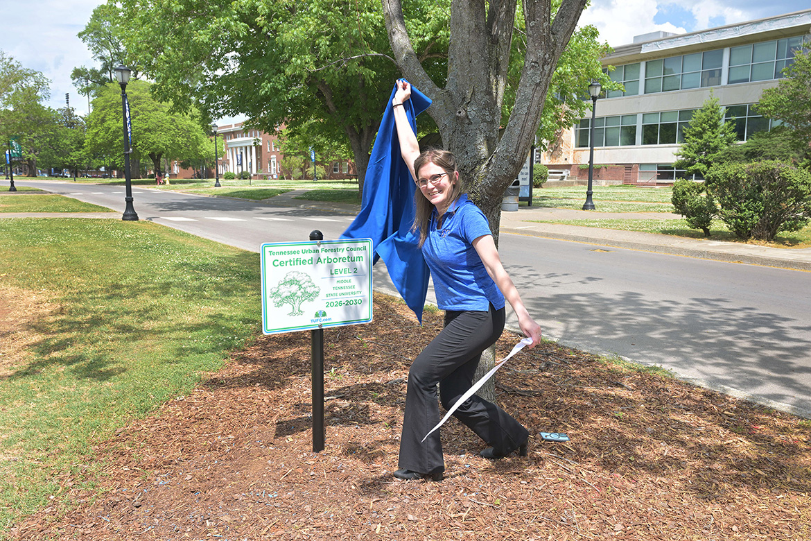 Kristen Hargis, assistant manager for the Center for Energy and Sustainability at Middle Tennessee State University in Murfreesboro, Tenn., unveils the sign designating campus as home to a Level II Arboretum that boasts 73 mapped and tagged trees across the 500-acre campus. The sign is located on Old Main Circle near Peck Hall. (MTSU photo by James Cessna)