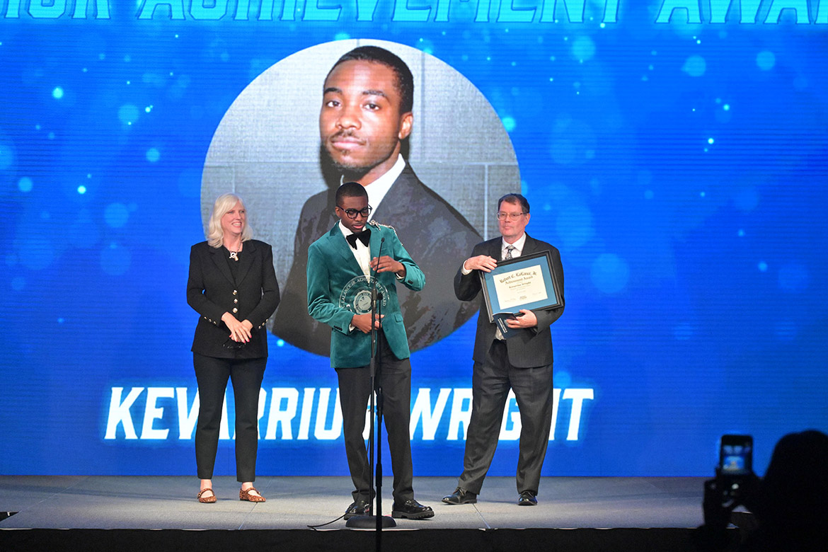 Senior media management major Kevarrius Wright, center, of Somerville, Tenn. accepts the Robert C. LaLance Jr. Achievement Award during the MTSU Bolt Awards ceremony held Tuesday, April 14, in the Student Union Ballroom on campus in Murfreesboro, Tenn. Standing behind Wright on stage are Scott Borchetta College of Media and Entertainment Dean Beverly Keel, left, and Danny Kelley, interim vice president for MTSU Student Affairs and dean of students, who presented him the award. (MTSU photo by James Cessna)