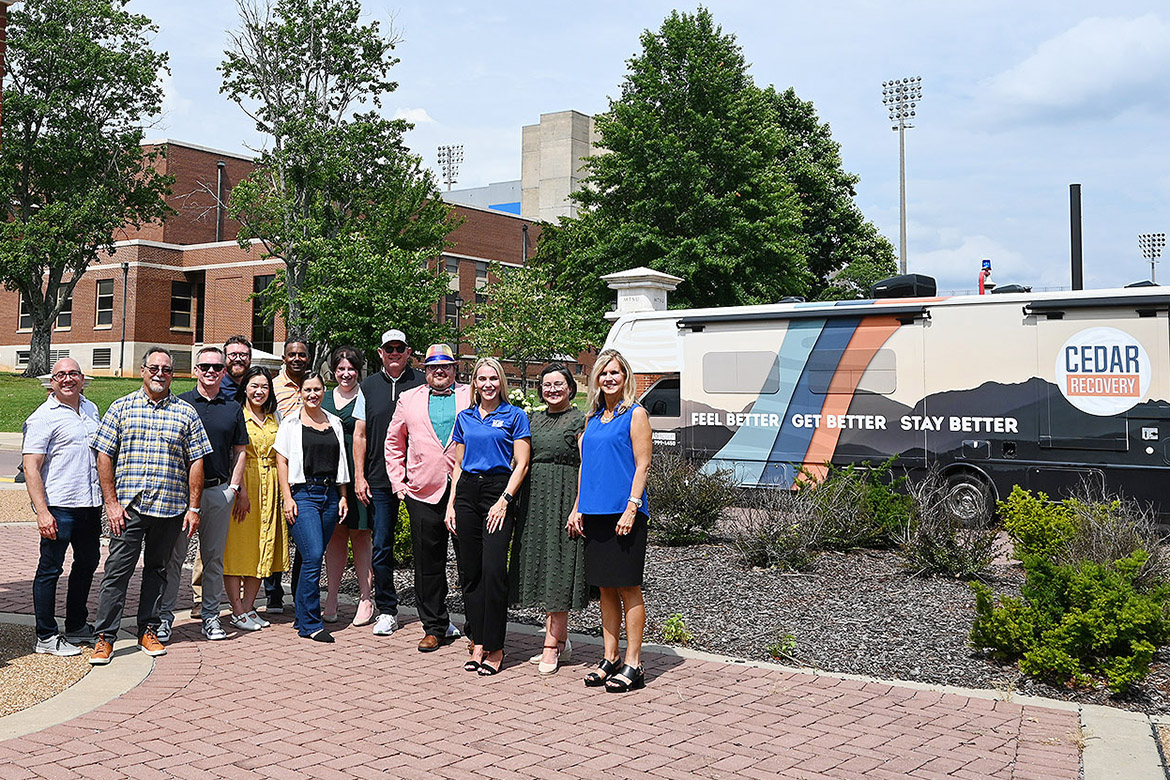 Representatives from the Center for Health and Human Services at Middle Tennessee State University and the Cedar Recovery addiction treatment company gather on the university campus in Murfreesboro, Tenn., to celebrate the new Cedar Recovery mobile addiction treatment clinic in the background that is being funded by a federal grant garnered by the MTSU center. (MTSU photo by Nancy DeGennaro)