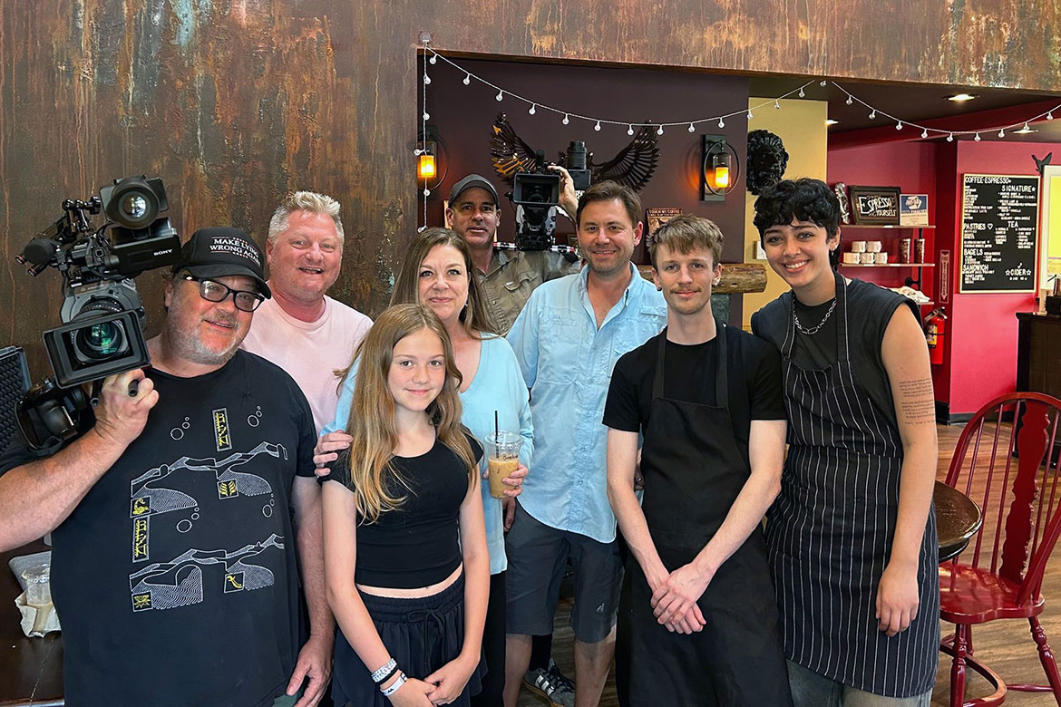 Middle Tennessee State University School of Journalism and Strategic Media professors Dan and Christine Eschenfelder, second row on the left, are pictured with the crew of HGTV’s “House Hunters” at local coffee shop The Dapper Owl in Murfreesboro, Tenn., during the filming of their episode “I’m Not a Hoarder.” (Submitted photo)