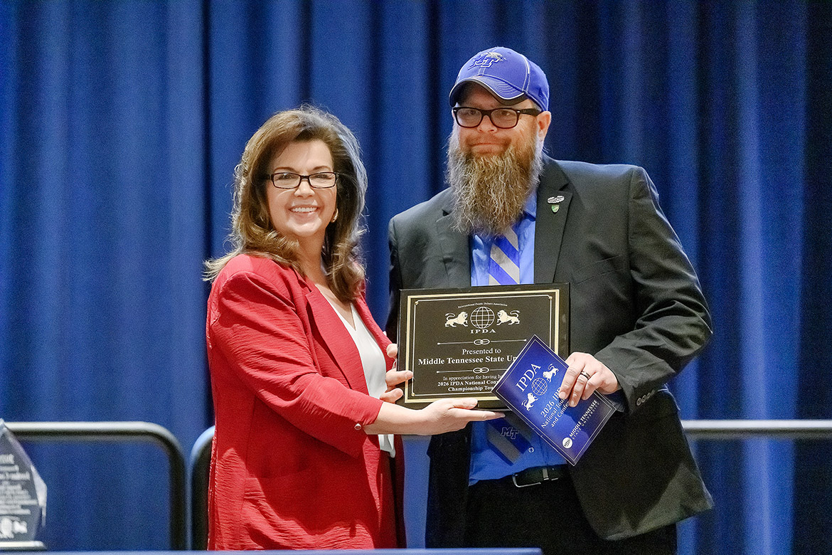 Sheila Ritchie, managing director for the International Public Debate Association Championships, presents Blue Raider Debate Team coach Pat Richey with a plaque at the conclusion of the four-day national tournament during an awards ceremony held April 13 in the James Union Building on campus at Middle Tennessee State University in Murfreesboro, Tenn. (MTSU photo by J. Intintoli)