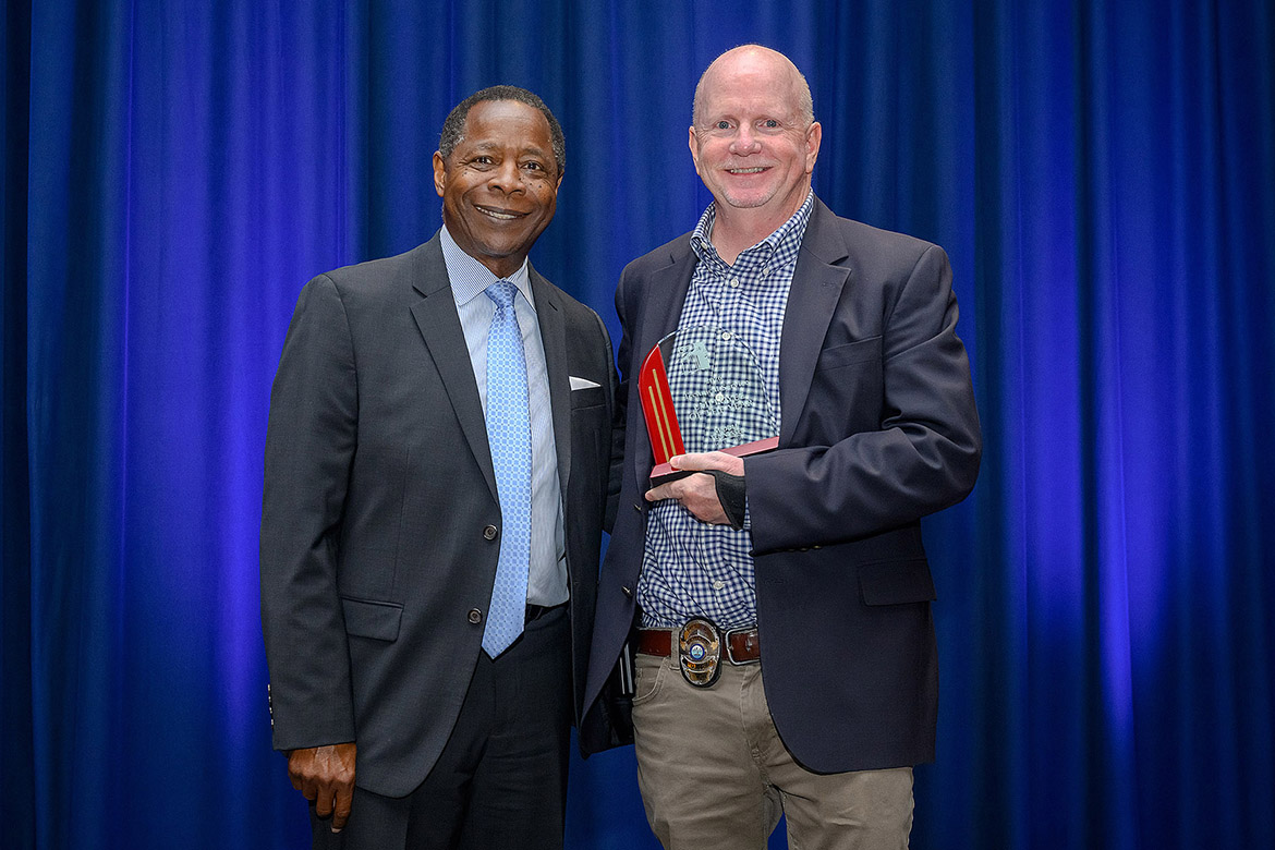 Middle Tennessee State University President Sidney A. McPhee, left, presents the 2025-26 Technical/Service Employee of the Year Award to MTSU Police Detective Tommy Roberts at the annual Employee Recognition Awards held Wednesday, April 22, in the James Union Building on campus in Murfreesboro, Tenn. (MTSU photo by Andy Heidt)