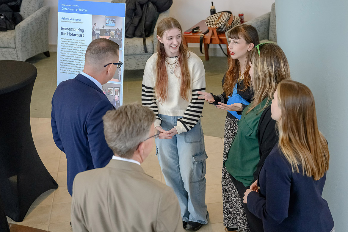 Brian Hinote, left, vice provost for Faculty and Strategic Initiatives at Middle Tennessee State University in Murfreesboro, Tenn., listens to student Bella Wallace, center, describe her work alongside faculty presenter Ashley Valanzola, far right, assistant professor of history whose project, “Remembering the Holocaust,” was featured at the Faculty Showcase held in March at Miller Education Center following the quarterly MTSU Board of Trustees meeting in March. (MTSU photo by J. Intintoli)