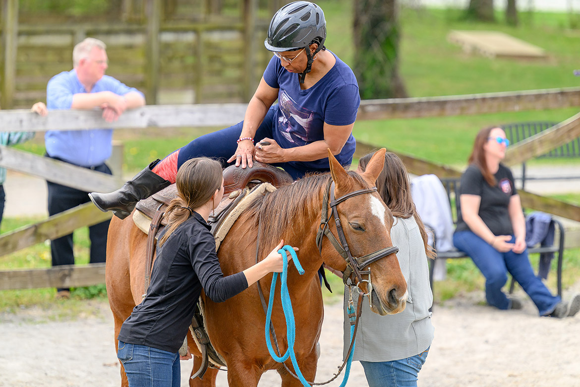 Margaret Kelley, a 21-year veteran of the U.S. Navy, dismounts a horse during an equine therapy session as part of the Middle Tennessee State University Center for Equine Recovery for Veterans program. Kelley overcame her fear of horses during the 10-week program that is made possible through a partnership with MTSU and the VA Tennessee Valley Healthcare System to help veterans in their recovery journeys. (MTSU photo by J. Intintoli)