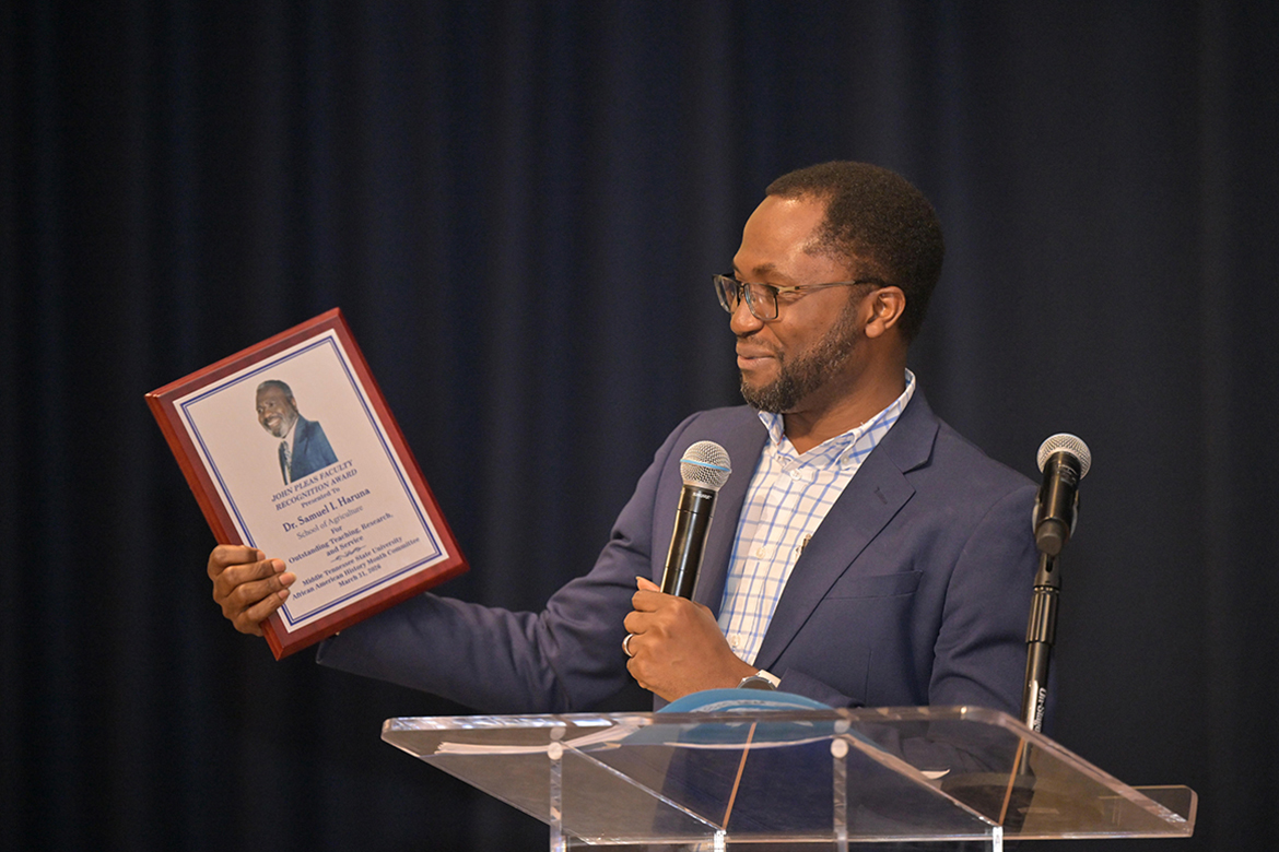Middle Tennessee State University associate professor of soil science Samuel Haruna, left, associate dean for academic programs in the College of Basic and Applied Sciences, accepts the 2026 John Pleas Faculty Award from MTSU Department of Psychology Professor Emeritus John Pleas at a ceremony held Tuesday, March 31, in the James Union Building on campus in Murfreesboro, Tenn. (MTSU photo by James Cessna)