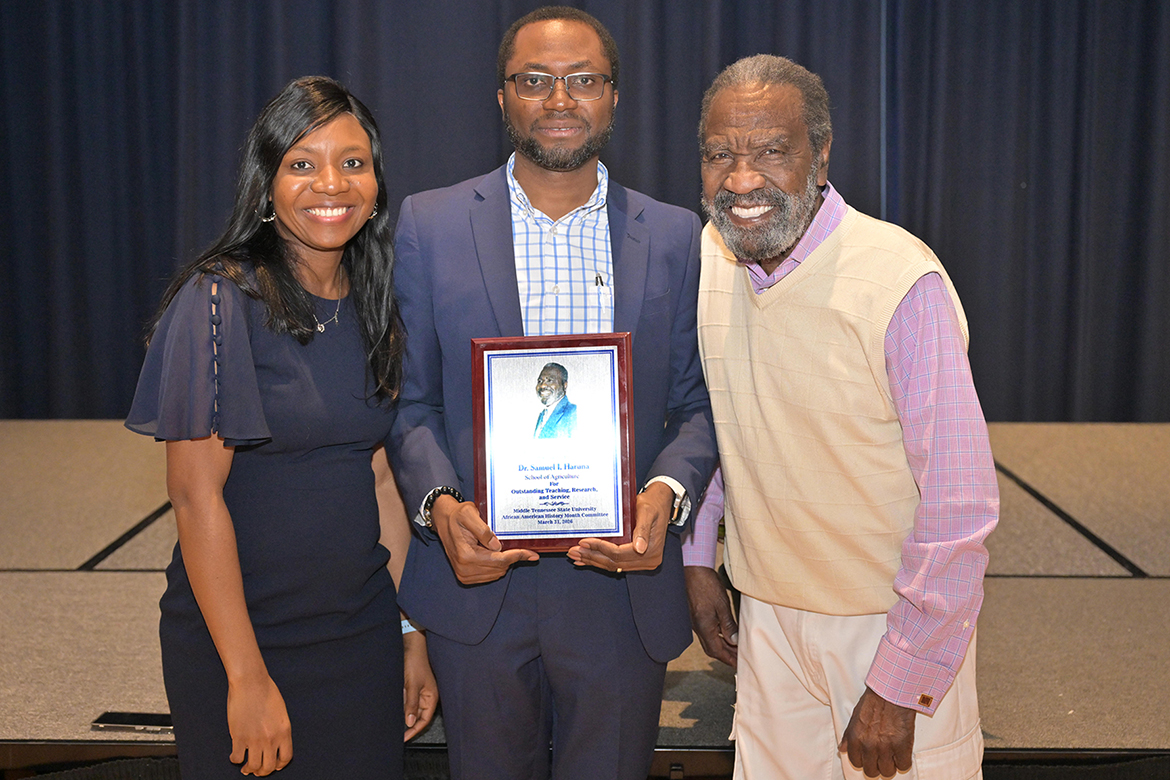 Middle Tennessee State University associate professor of soil science Samuel Haruna, associate dean for academic programs in the College of Basic and Applied Sciences, was presented the 2026 John Pleas Faculty Award at a ceremony held Tuesday, March 31, in the James Union Building on campus in Murfreesboro, Tenn. Standing with Haruna, center, is his wife, Gloria Haruna, and the award’s namesake, John Pleas, professor emeritus in the MTSU Department of Psychology. (MTSU photo by James Cessna)