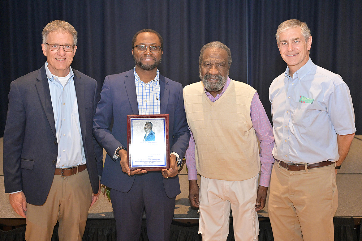 Middle Tennessee State University associate professor of soil science Samuel Haruna, center, holds the 2026 John Pleas Faculty Award he accepted during a ceremony held Tuesday, March 31, in the James Union Building on campus in Murfreesboro, Tenn. Pictured are, from left, MTSU Provost Mark Byrnes, Haruna, Professor Emeritus John Pleas and College of Basic and Applied Sciences Dean Greg Van Patten. (MTSU photo by James Cessna)
