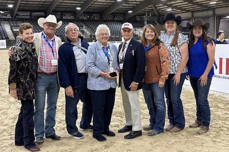 A smiling Anne Brzezicki, center left, Middle Tennessee State University’s prolific former director of Equestrian programs, equestrian team coach and horse science instructor, holds the award she received as an inductee during the Intercollegiate Horse Show Association’s Hall of Fame Induction Ceremony held during the association’s 2026 National Championships, Friday, May 1, at the Tryon International Equestrian Center in Mill Spring, N.C. Pictured, from left, are Tara Boyce, Brzezicki’s 1972 teammate; Peter Cashman, IHSA’s executive director; Michael Brzezicki, her husband; Brzezicki; Bob Cacchione, IHSA founder; Rhonda Hoffman, director of MTSU’s Horse Science program; Ariel Higgins, MTSU’s director of Equestrian programs; and Andrea Rego, director of MTSU’s Center of Equine Recovery for Veterans and the university’s Stock Horse team coach. (Submitted photo)