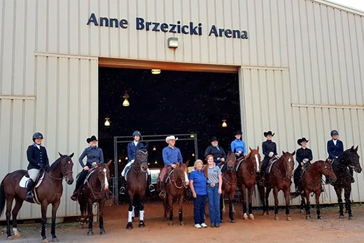 Anne Brzezicki, standing center left, Middle Tennessee State University’s former director of Equestrian programs, equestrian team coach and horse science instructor, poses for a photo with Ariel Higgins, right of Brzezicki, her successor as MTSU’s director of Equestrian programs and her former student, along with members of the MTSU equestrian team at the naming of the MTSU Anne Brzezicki Arena in Murfreesboro, Tenn, in 2017. (Submitted photo)