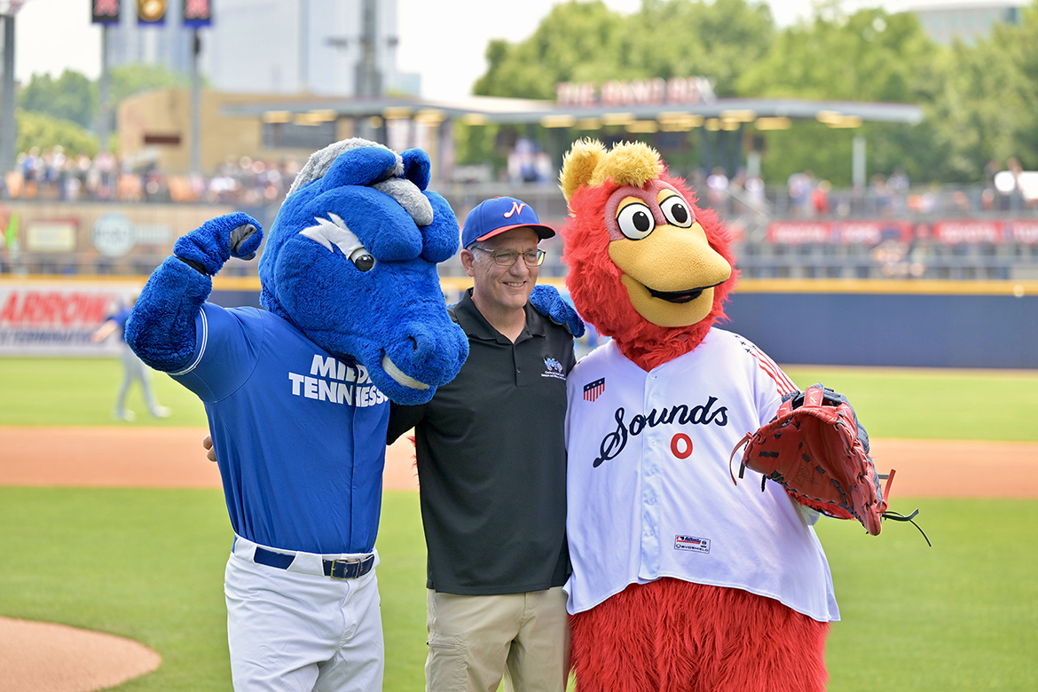 Mark Byrnes, center, provost at Middle Tennessee State University in Murfreesboro, Tenn., poses with Nashville Sounds mascot Booster, right, and MTSU mascot Lightning on baseball field.
