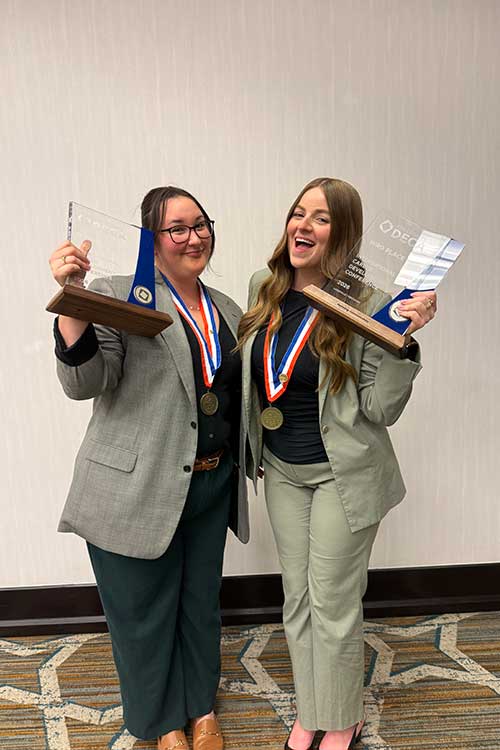 Savanah Gill, left, and Ella Cobb, both Jones College of Business students at Middle Tennessee State University in Murfreesboro, Tenn., are all smiles holding their medallions and glass trophies they received after placing third at the Collegiate DECA Marketing Communications competition during the International Career Development Conference held in Louisville, Kentucky, in April. (Photo submitted)