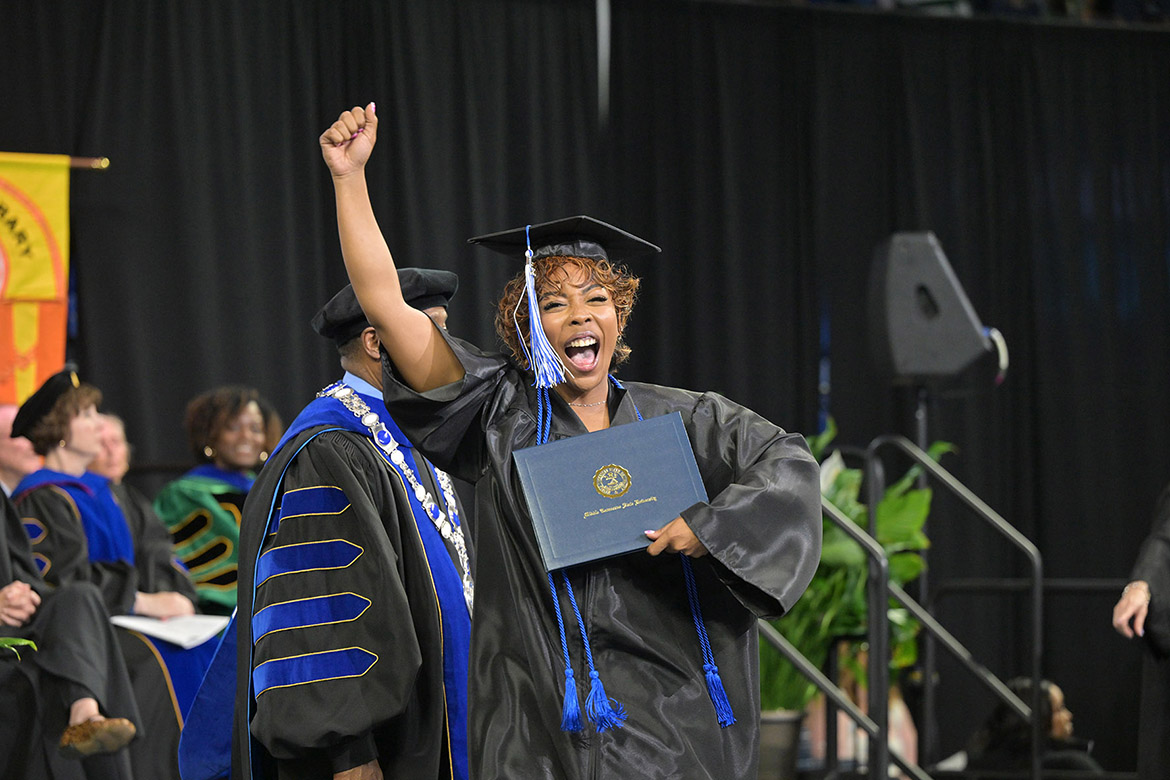 A proud Class of 2026 graduate gives a fist pump and cheers while holding her newly awarded diploma during the afternoon commencement ceremony held Saturday, May 9, inside Murphy Center at Middle Tennessee State University in Murfreesboro, Tenn. (MTSU photo by James Cessna)