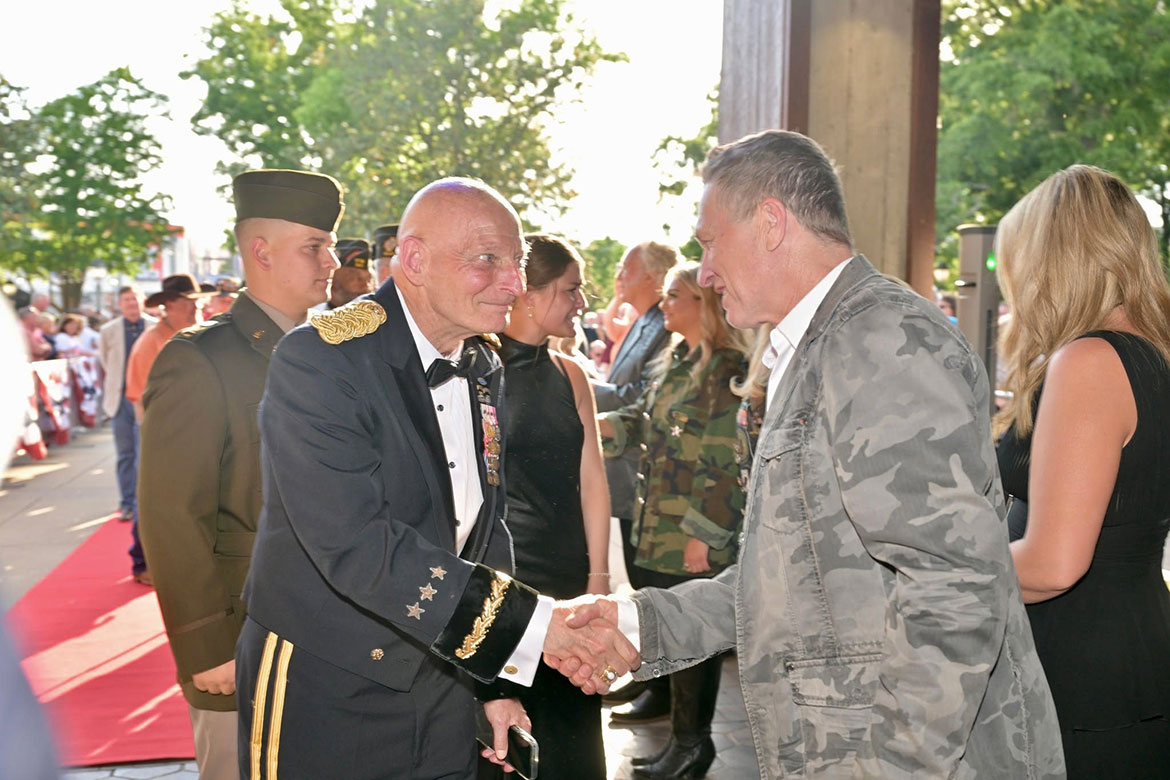 Retired Army Lt. Gen. Keith Huber, MTSU's senior advisor for veterans and leadership initiatives (left), shakes hands with Grand Ole Opry member and former MTSU student Craig Morgan, who serves as an Army Reserve Warrant Officer, during the red-carpet parade before the Opry’s 2026 Salute the Troops event  (MTSU Photo by James Cesssna)