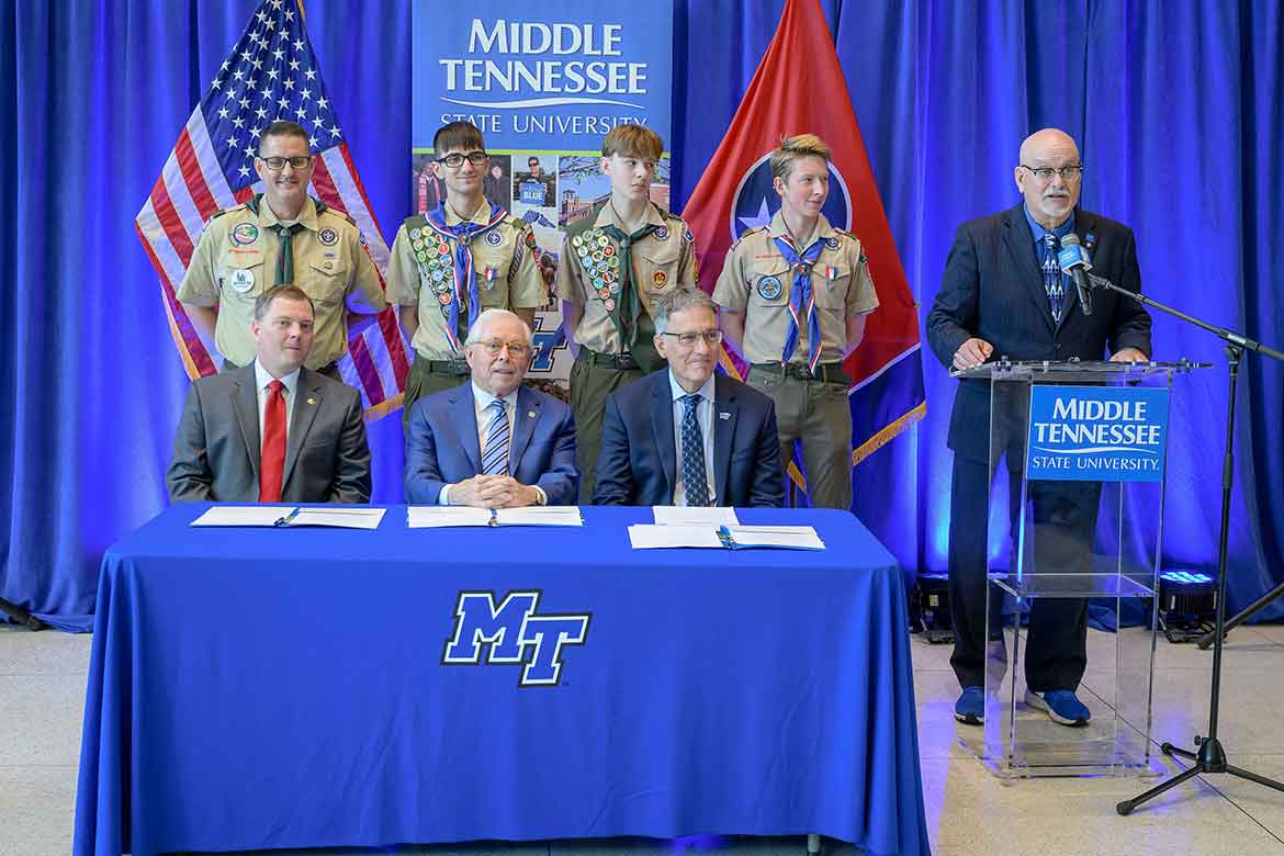 Andrew Oppmann, right, Middle Tennessee State University vice president for marketing and communications and an Eagle Scout, speaks during a campus ceremony to renew the university's longstanding partnership with the Middle Tennessee Council of Scouting America. Pictured back row, from left, are MTSU Vice Provost Brian Hinote, an adult Scouting leader with Troop 1108 in Murfreesboro, Tenn., and three Scouts. Seated front row, from left, are Council Scout Executive and CEO Robert Johnson; MTSU Board of Trustees member J.B. Baker, a former Council president and an Eagle Scout; and university Provost Mark Byrnes. (MTSU photo)
