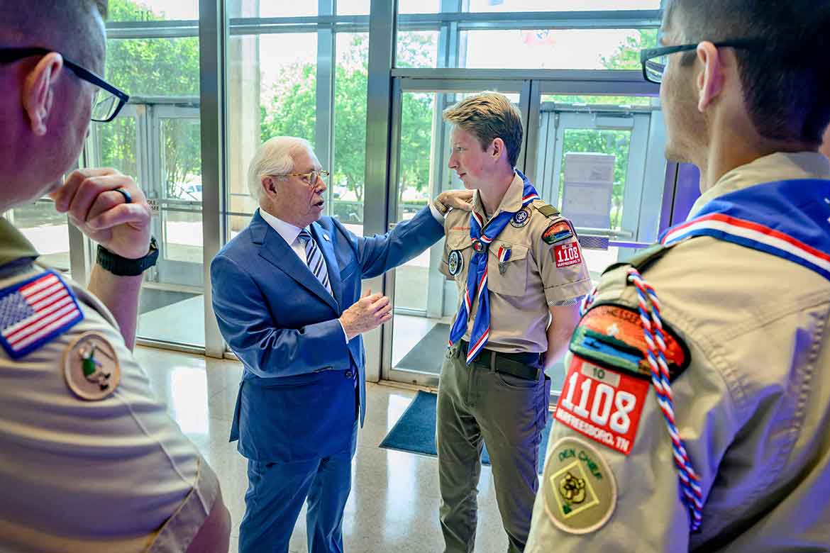 Middle Tennessee State University Board of Trustees member J.B. Baker, left, a former Council president and an Eagle Scout, speaks to a current Scout after a renewal ceremony between the university and the Middle Tennessee Council of Scouting America. Vice Provost Brian Hinote, an adult Scouting leader with Troop 1108 in Murfreesboro, Tenn., left, and another Scout watch. (MTSU photo)