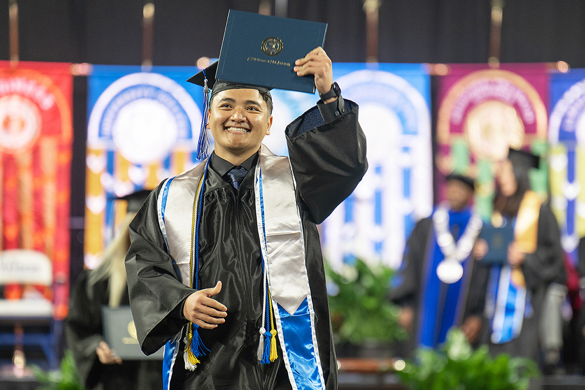A proud Class of 2026 graduate holds up his diploma cover during the afternoon commencement ceremony held Saturday, May 9, inside Murphy Center at Middle Tennessee State University in Murfreesboro, Tenn. (MTSU photo by Cat Curtis Murphy)