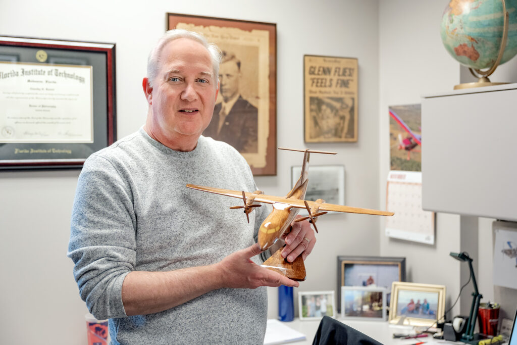 Tim Rosser poses for portraits in his office and discusses exam materials with students.