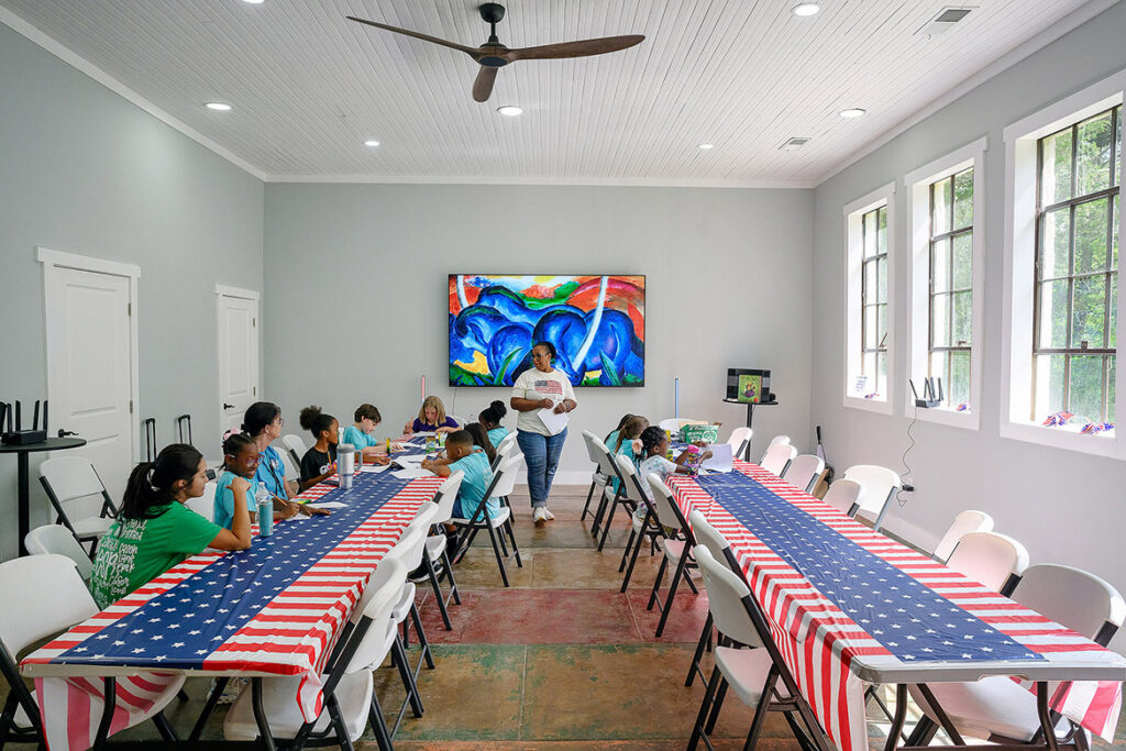 Retired Murfreesboro City Schools teacher and Middle Tennessee State University alumna Helen McKnight, center, teaches students about American symbols during Patriot Camp held at the newly renovated Cemetery School located off Old Nashville Highway just outside Murfreesboro, Tenn., which was once the heart of a thriving Black community. The MTSU Center for Historic Preservation was instrumental in preserving the site. (MTSU photo by Andy Heidt)