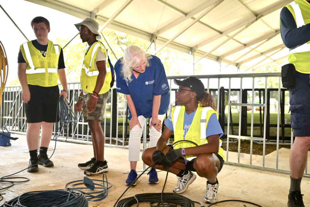 Beverly Keel, third from left, dean of the Scott Borchetta College of Media and Entertainment at Middle Tennessee State University in Murfreesboro, Tenn., chats with an MTSU Media Arts student worker on June 10, 2026, at this year’s Bonnaroo Music and Arts Festival to be held Friday-Sunday, June 11-14, in Manchester, Tenn. (MTSU photo by J. Intintoli)