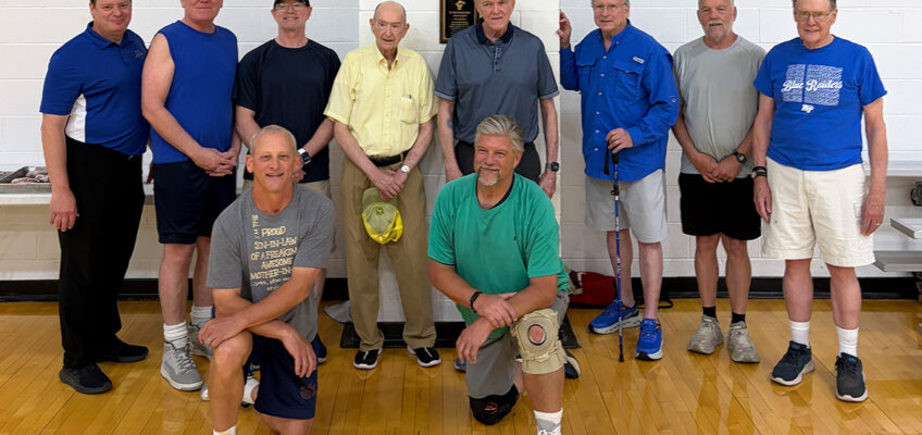 Omri Rawlins, back row, fourth from left, stands with fellow members of the “Noon Basketball Association” gathered around a plaque dedicated in his honor inside the Middle Tennessee State University Campus Recreation Center in Murfreesboro, Tenn. The Rec recently dedicated a basketball court to Rawlins, a retired longtime faculty member who served as the group's longtime 