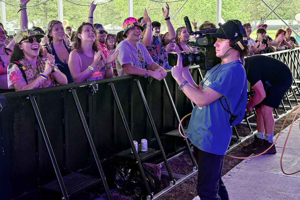 A video and film production student from Middle Tennessee State University in Murfreesboro, Tenn., films the fan experience during a performance at the Bonnaroo Music and Arts Festival held June 11-14, 2026, in Manchester, Tenn. (MTSU photo by Andrew Oppmann)